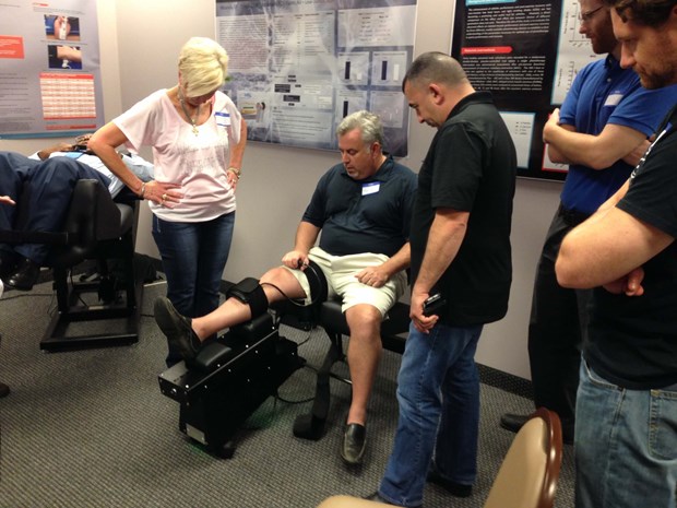 Back on Trac CEO Linda Anderson helps an attendee try out the Knee on Trac System