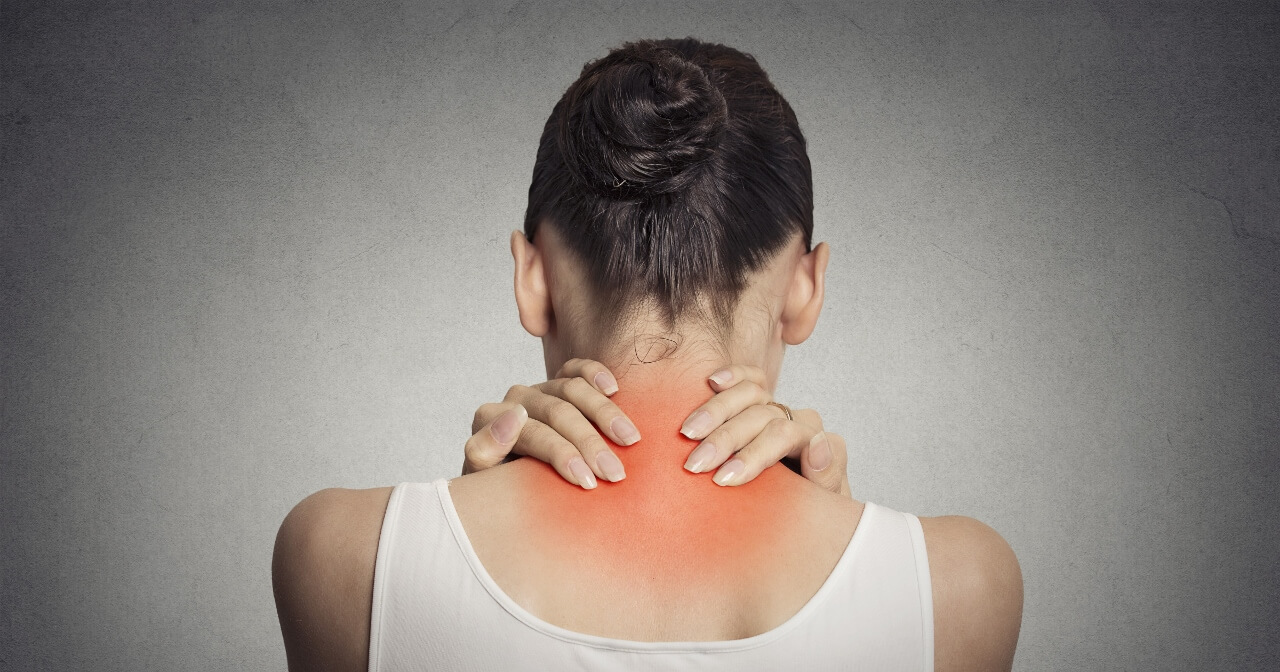 Woman holding back of neck in pain
