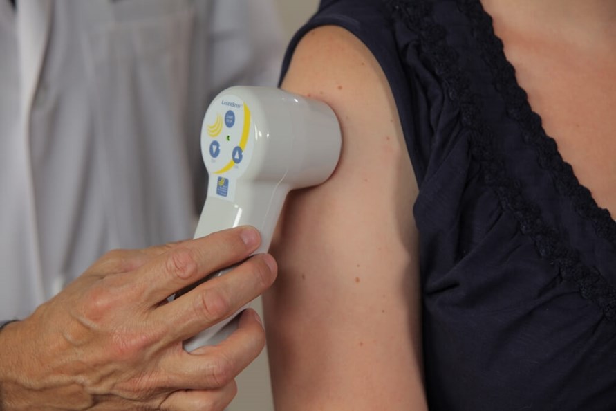 Doctor holds Multi Radiance MR4 LaserStim emitter onto patient's arm